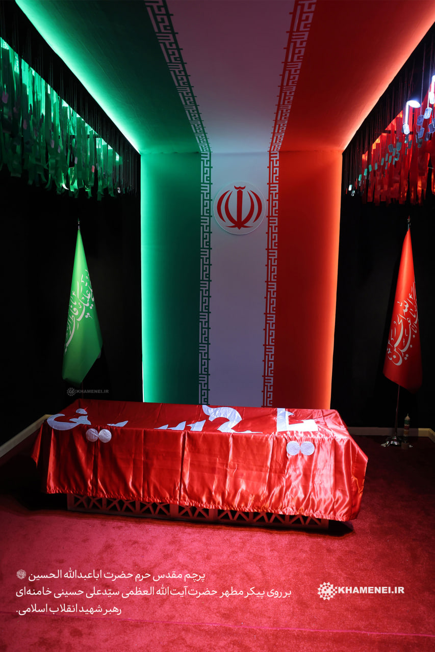 تصویر پرچم مقدس حرم امام حسین علیه السلام بر روی تابوب مطهر رهبر شهید سیدعلی خامنه ای